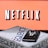 A screen displaying the Netflix logo in bold, black and white lettering against a vibrant red background. In front of the screen, there is a closed box for the board game 'Sequence', with a smartphone and wireless earbuds resting on top.
